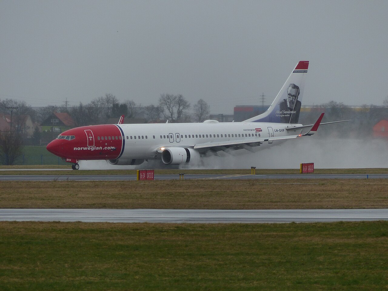 Et Norwegian-fly lander på våt rullebane